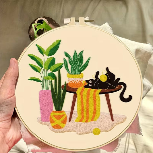 Close-up of finished black cat embroidery design with colorful plants