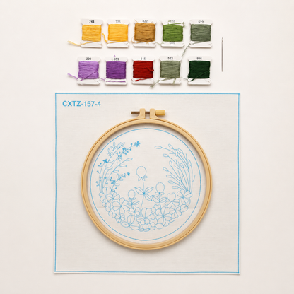 Embroidery hoop with floral design and thread colors on a light background